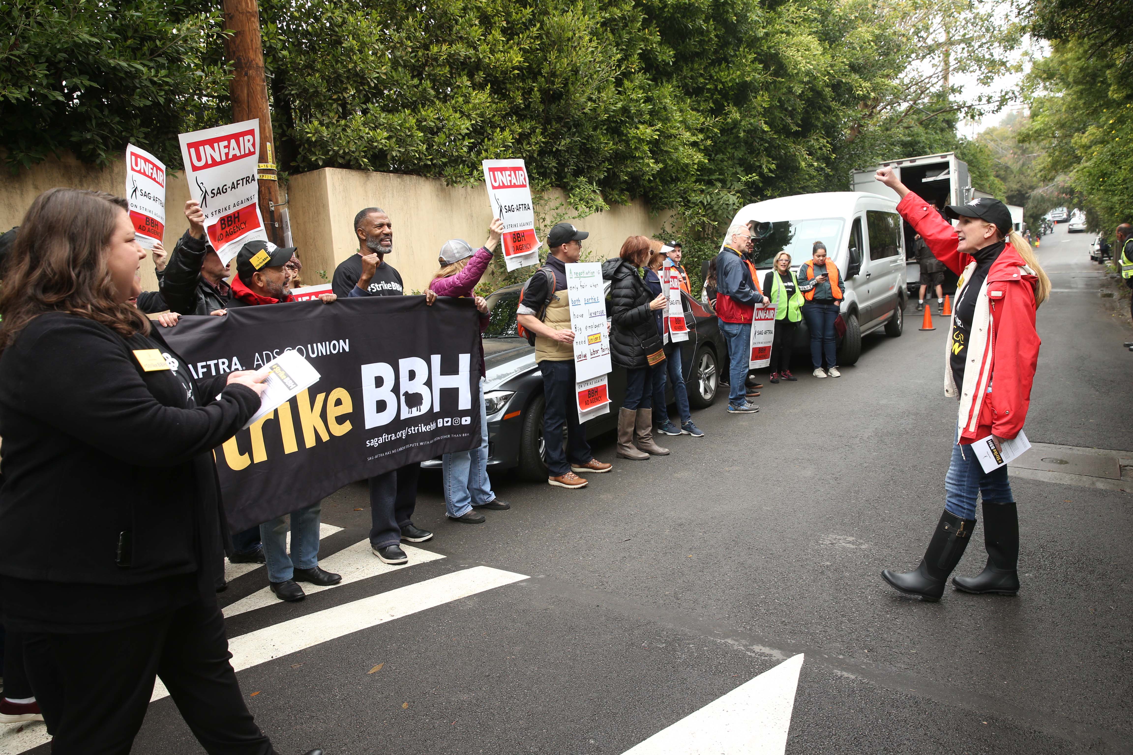 Members line the street with banners and posters saying we're on strike against BBH.