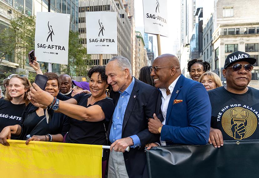 La vicepresidenta de Nueva York, Linda Powell, el líder de la mayoría del senador, Chuck Schumer, y el presidente local de Nueva York, Ezra Knight, posan para una selfie.