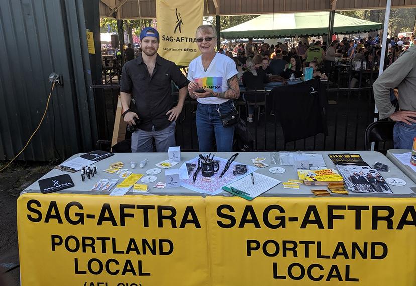 Los miembros de Portland Local Jeff Rock y Gwyn Laree se ofrecieron como voluntarios en la mesa de información del local en el picnic del Día del Trabajo de 2019. Foto de Harold Phillips.