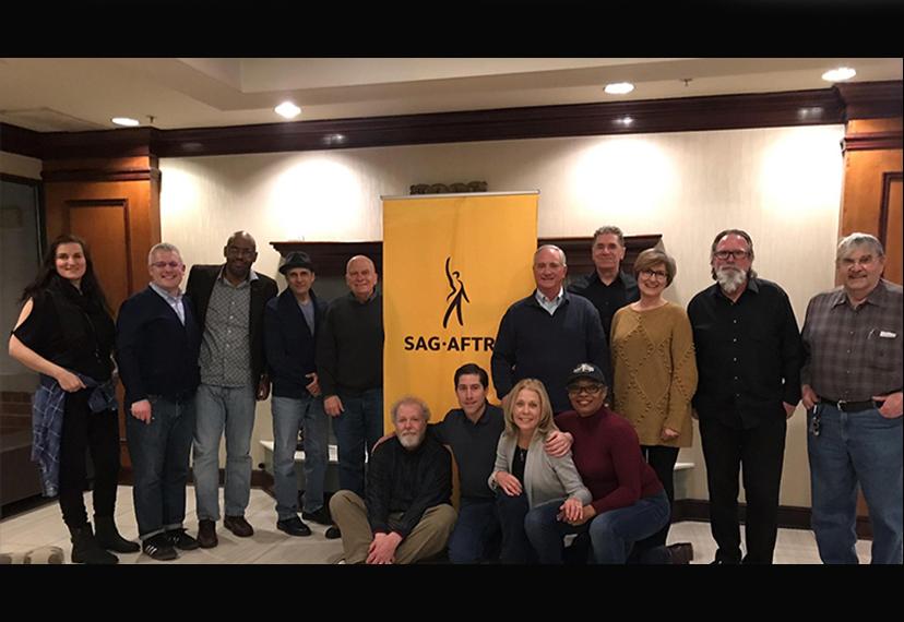 Foto grupal de miembros con sede en Cleveland con pancarta SAG-AFTRA en el centro del fondo.