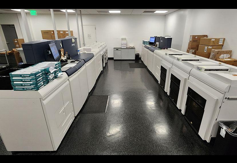 Una máquina de correo Quadient dobla los cheques y estados de cuenta, los pasa por un medidor de franqueo y los prepara para enviar por correo. Luego, un escáner leerá los códigos de barras y los cheques y estados de cuenta se insertarán en los sobres.