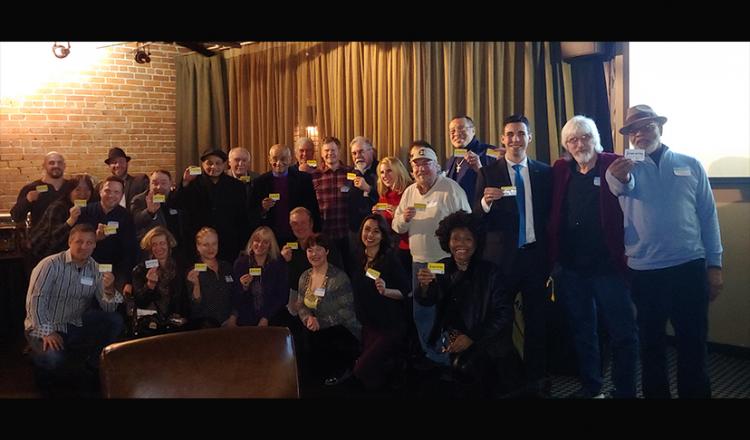 Foto grupal de miembros de SAG-AFTRA con sede en Pittsburgh que sostienen sus tarjetas sindicales.