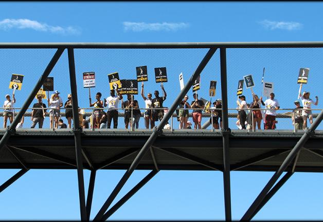 Miembros de SAG-AFTRA, familiares y amigos en un puente peatonal durante el piquete en NBCUniversal. Foto de Jack E. Herman.
