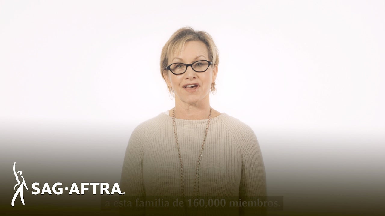 Carteris in beige long sleeve standing in front of a white background