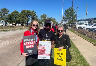 Two women and one man, CeeJay Joseph (Black) outside on the sidewalk. The women, flight attendants, are dressed in their uniforms; Joseph wears a black SAG-AFTRA sports hat and "SAG-AFTRA Strong" t-shirt. Each holds a strike sign.