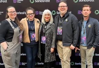Johnson, Cristiano, Traister, Crabtree-Ireland y Aguirre se encuentran frente a un telón de fondo negro del Denver Film and SeriesFest que se repite y se repite. Todos visten ropa informal y cordones con insignias de colores.