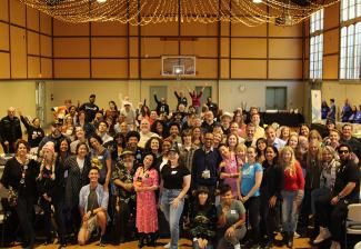 A crowd gathers for a photo in a gym.