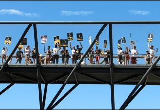 SAG-AFTRA members, family and friends on a pedestrian bridge during the picket at NBCUniversal. Photo by Jack E. Herman. 