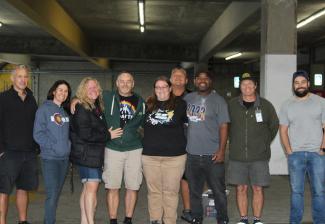 People stand for a group shot in a parking garage.