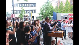 Executive Vice President Rebecca Damon looks on as New York Gov. Andrew Cuomo on holds up newly signed legislation that expands the state’s equal pay laws July 10.