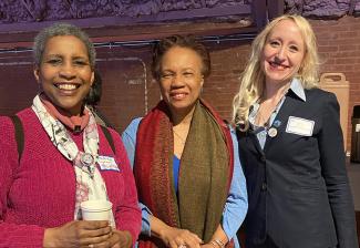 Lyman, dressed in maroon and wearing a scarf, holds a coffee cup. Simmons, in blue, wears a brown scarf. Strezo is dressed in a dark siut.