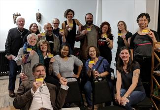 Un grupo diverso de hombres y mujeres representan una foto grupal y muestran sus tarjetas de membresía.