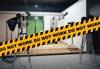 Cinta de precaución que dice "No trabajar" frente a un set de filmación