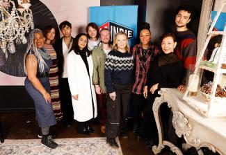 A diverse group of nine individuals in a restaurant setting.