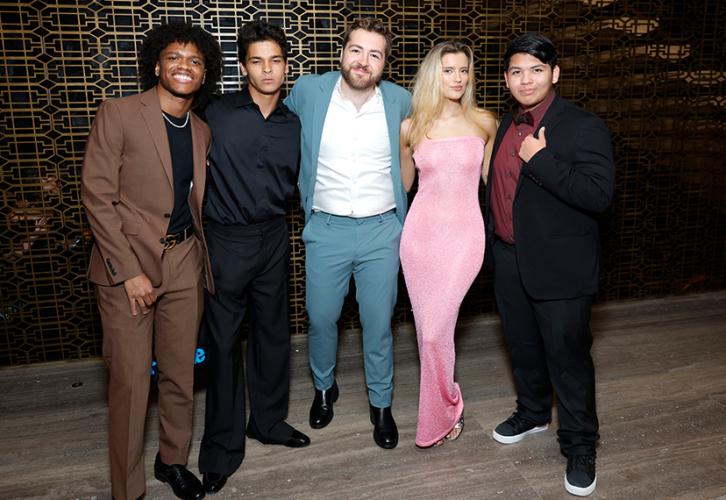 From left, Alexander, Woon-A-Tai, Gandolfini, Healey and Factor stand closely together. Alexander wears a brown suit, black shirt and chain; Woon-A-Tai, an all-black outfit; Gandolfini, a teal suit and white dress shirt; Healey, a pink dress; and Factor, a black suit, brown shirt, bowtie and sneakers. Behind them is a wall patterned with geometric shapes in gold.