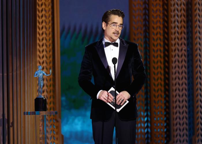 Colin Farrell stands on stage. Beside him is the SAG Awards statuette. 