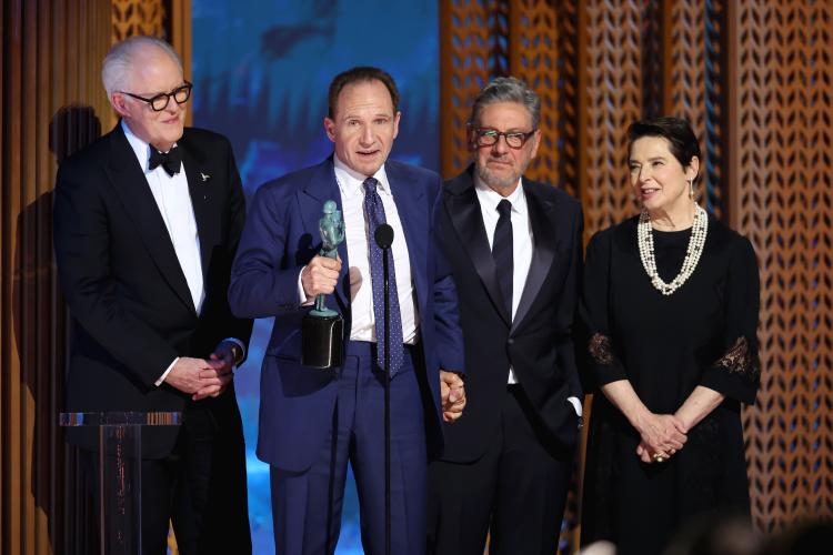 From left, John Lithgow, Ralph Fiennes, Sergio Castellitto and Isabella Rossellini on stage. Fiennes speaks into a microphone.
