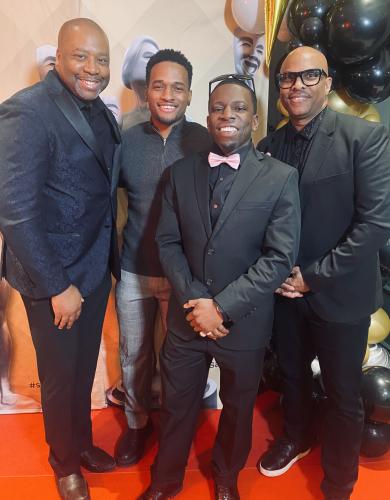 Four African American men, from left, Curtis, Elsima, Perkins and Williams stand for a photo. They all dressed in formalwear, with all but Elsmia in suits. Perkins’ glasses are perched atop his head and he wears a pink bowtie.