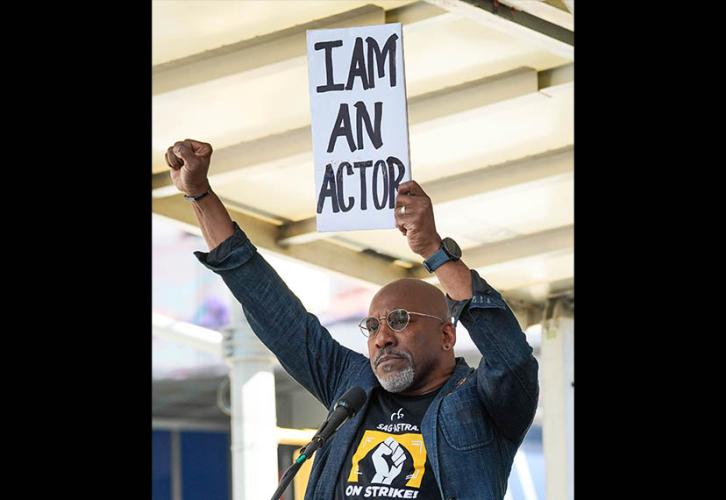 SAG-AFTRA member Ezra Knight holds up a sign with the words “I Am An Actor.”