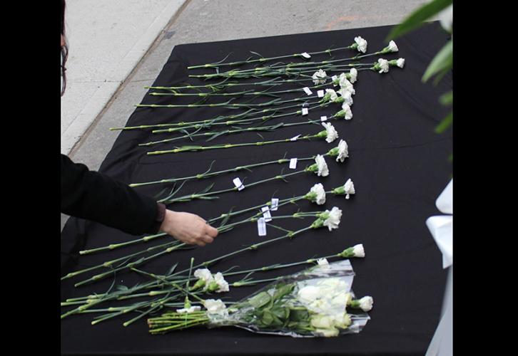 A bell rang and a white flower was laid as the name of each of the 146 victims was called out.