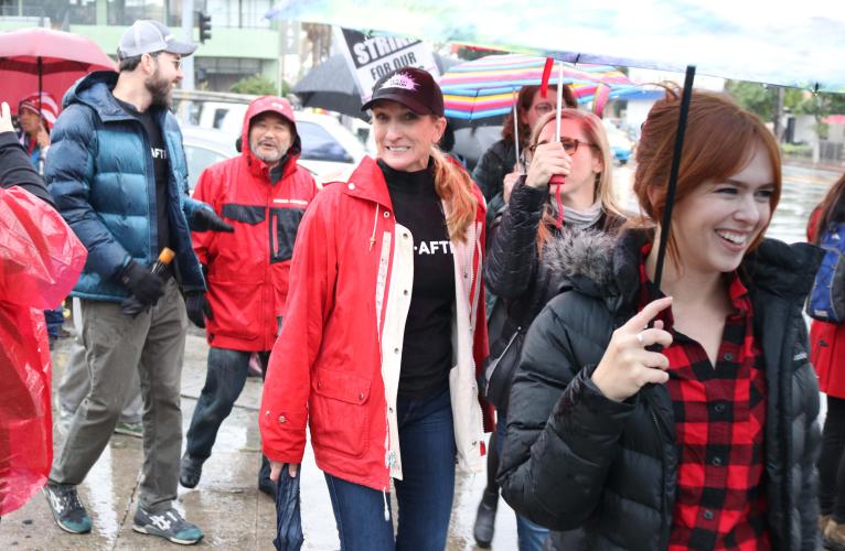Austin walking with fellow members in a red coat and SAG-AFTRA t-shirt