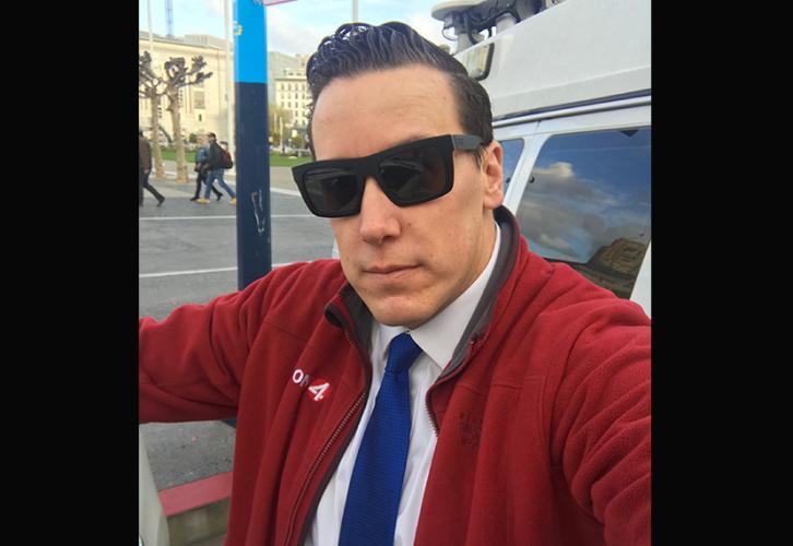 Broadcaster J.R. Stone sports a blue tie and sunglasses.