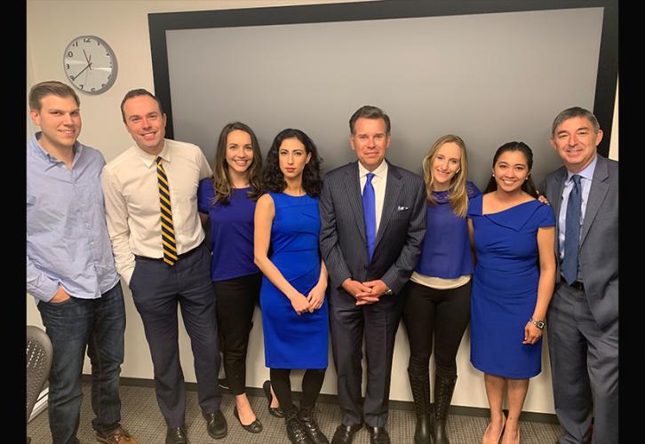 A group of men and women wear blue. 