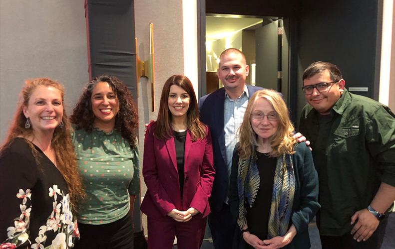 From left, Escobedo, Fata (South Asian American), Stefani, Delorio, Howell and Castillo (Latino) take a photo in a nondescript room. All wear business casual attire.