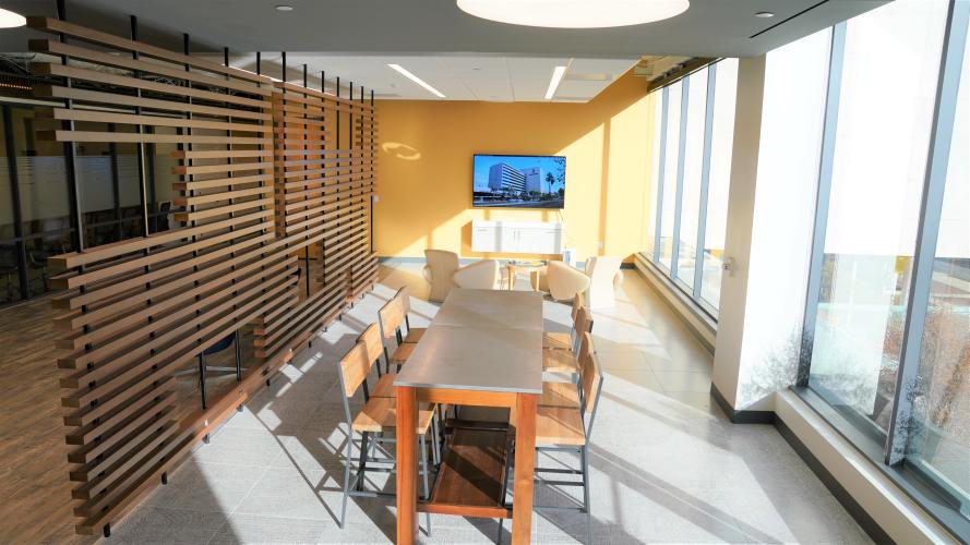 Dining Tables with 4 chairs on each side and a TV mounted on the wall
