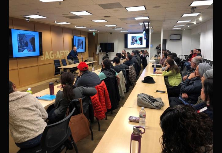 Jorge Reyes from Penguin Random House Grupo Editorial addresses a crowd of individuals in the SAG-AFTRA Maxwell Conference Room.