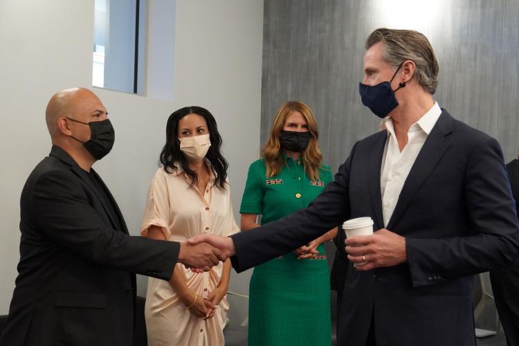 California Gov. Gavin Newsom, right, shakes hands with LiUNA!Local 724 Business Manager Alex Aguilar, left, while Assembly member Autumn Burke and California Film Commission Director Colleen Bell look on.