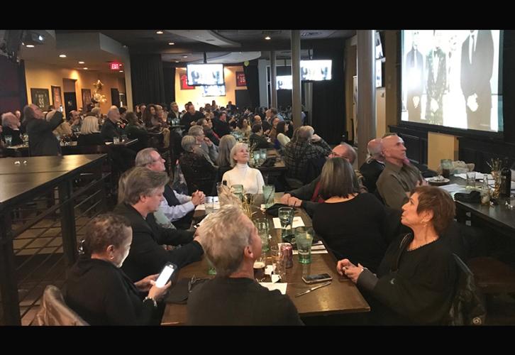 Una mesa de hombres y mujeres sentados en la fiesta.