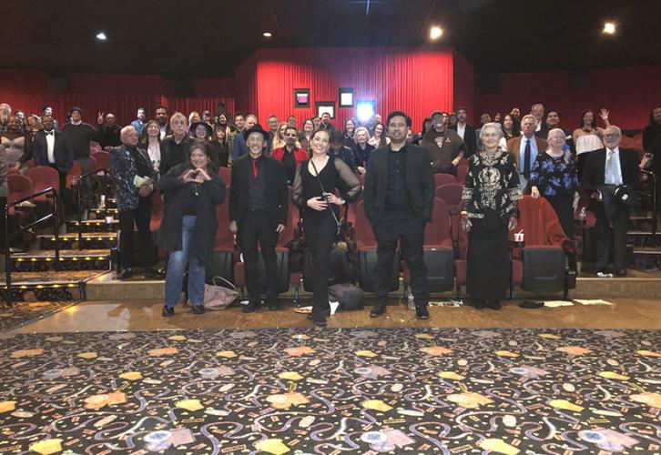 A photo of a large group inside a movie theater. 