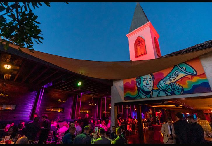 Attendees are seated outside of the Chapel in twilight with low purple lights. 