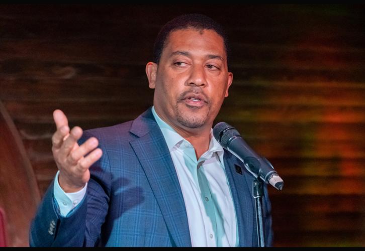 NED David White, standing at a mic and addressing the crowd with his gaze focused off-screen.