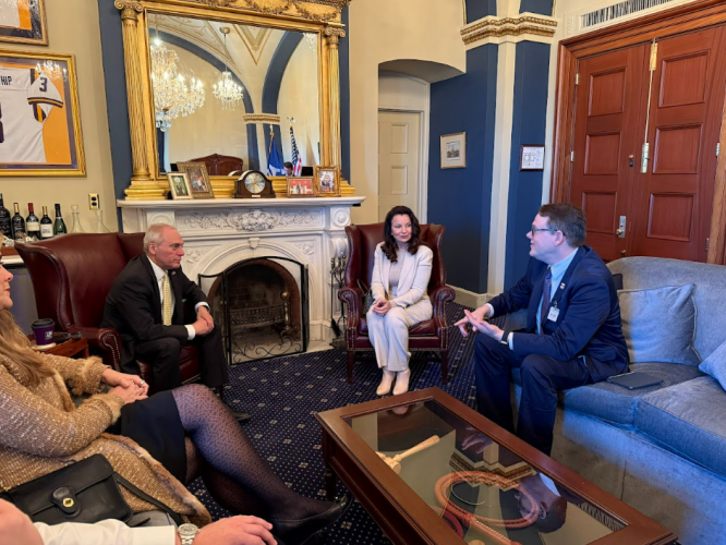 SAG-AFTRA President Fran Drescher, center, with Senator Chris Coons, left, and SAG-AFTRA National Executive Director Duncan Crabtree-Ireland talking in an ornate room at the Capitol.