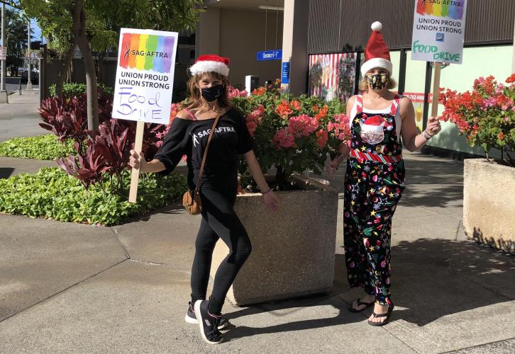 Hawaii Local Board members Lisa Romano and Heather Pence direct members to the drive-by food drop off.