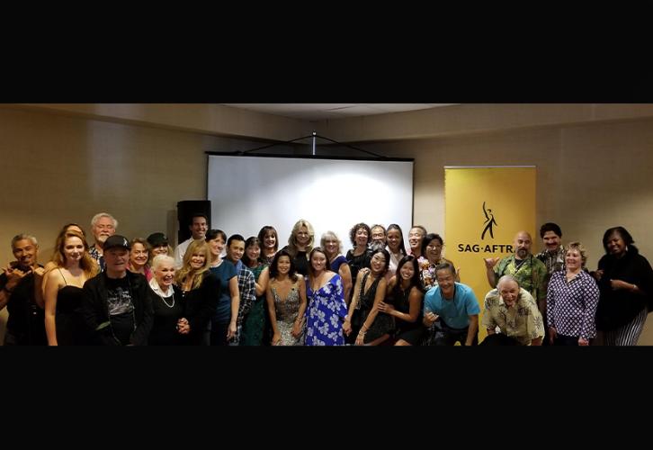Hawaii Local members stand in front of a projection screen and SAG-AFTRA banner.