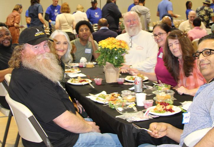 The group sits at a table with plates of food.