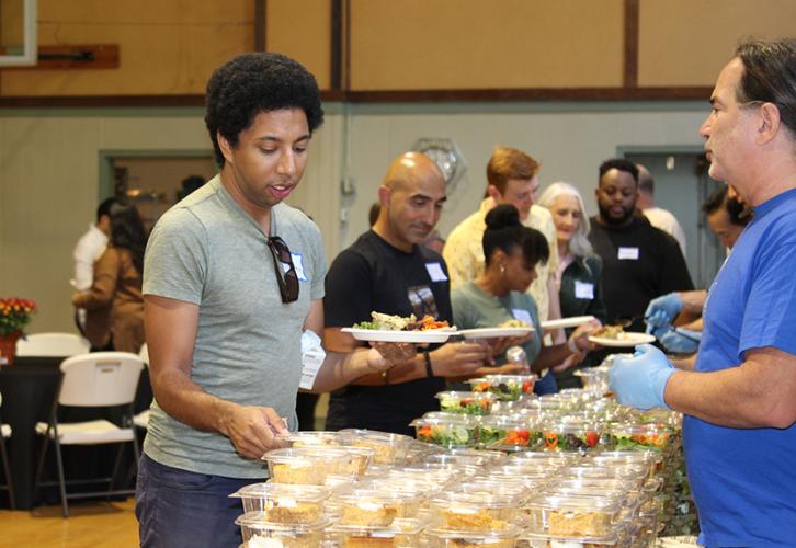 A man takes food items at a buffet with prepackaged food.