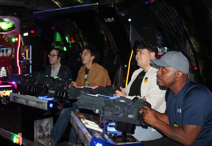 Strike captains Henry, Belardinelli, Dager and McGregory operate plastic guns while playing a video game.