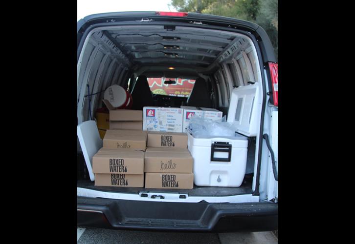 A van filled with boxes with its rear doors open.