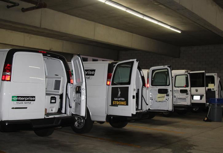 Vans in a parking garage, with their rear doors open.