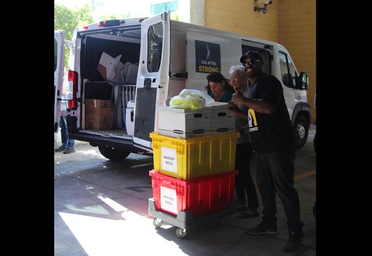 Three people unloading a van.