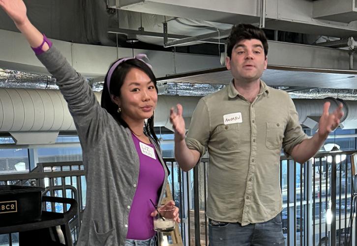Eng, in a gray sweater and purple top, holds her arm up. Smith, in a beige button-up shirt, gestures with his hands.