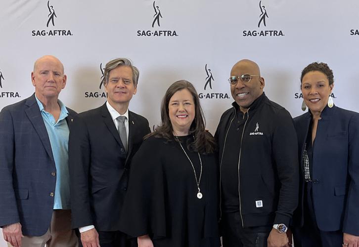 Five people smile in front of a white step-and-repeat with Sag-Aftra in black text.