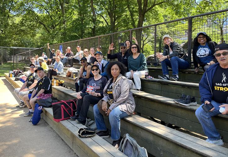 A crowd of people are seated on bleachers. 