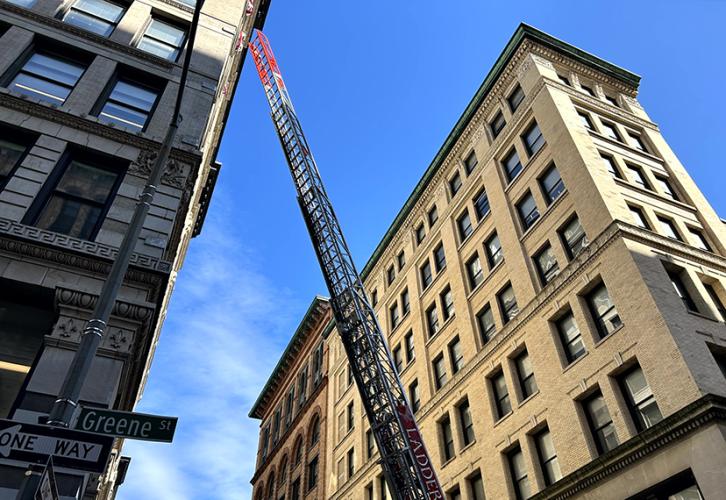 The FDNY raises a ladder to the upper floors of a building at the Triangle Fire Memorial dedication.
