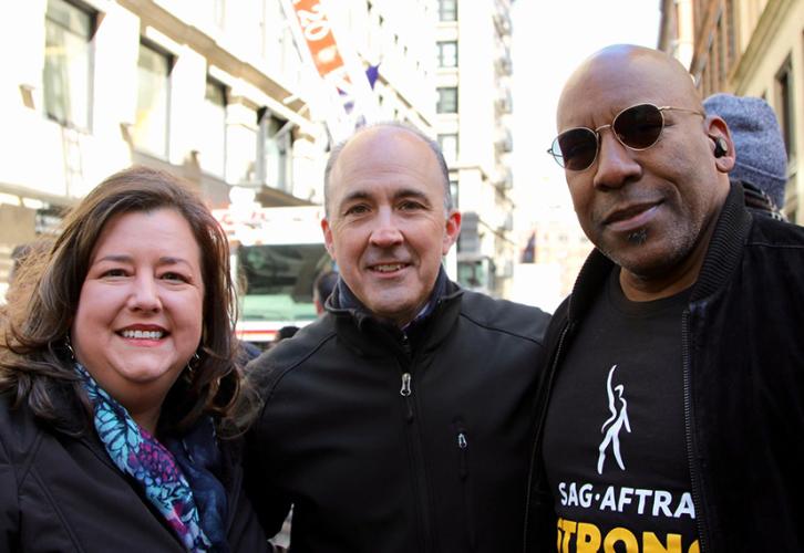 Damon, Alvarez and Knight are dressed in black. Knight wears sunglasses and a fire engine can be seen in the background.