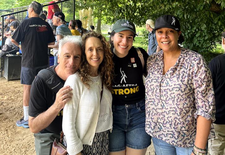 A man and three women stand side by side, smiling at the camera.